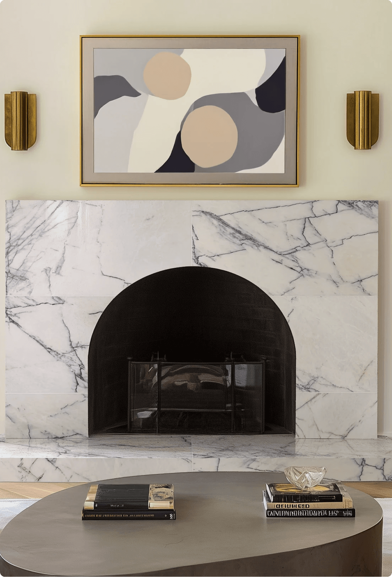 Elegantly styled living room fireplace with white marble surround, a framed abstract artwork, and brass wall sconces