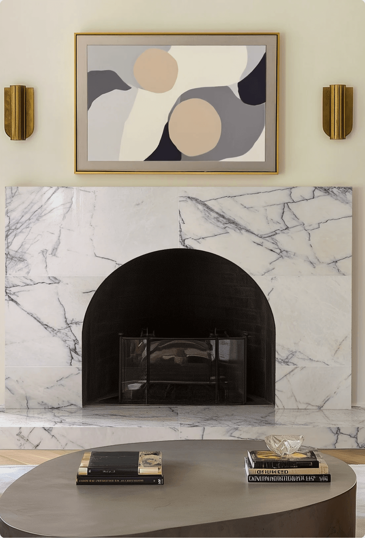 Elegantly styled living room fireplace with white marble surround, a framed abstract artwork, and brass wall sconces