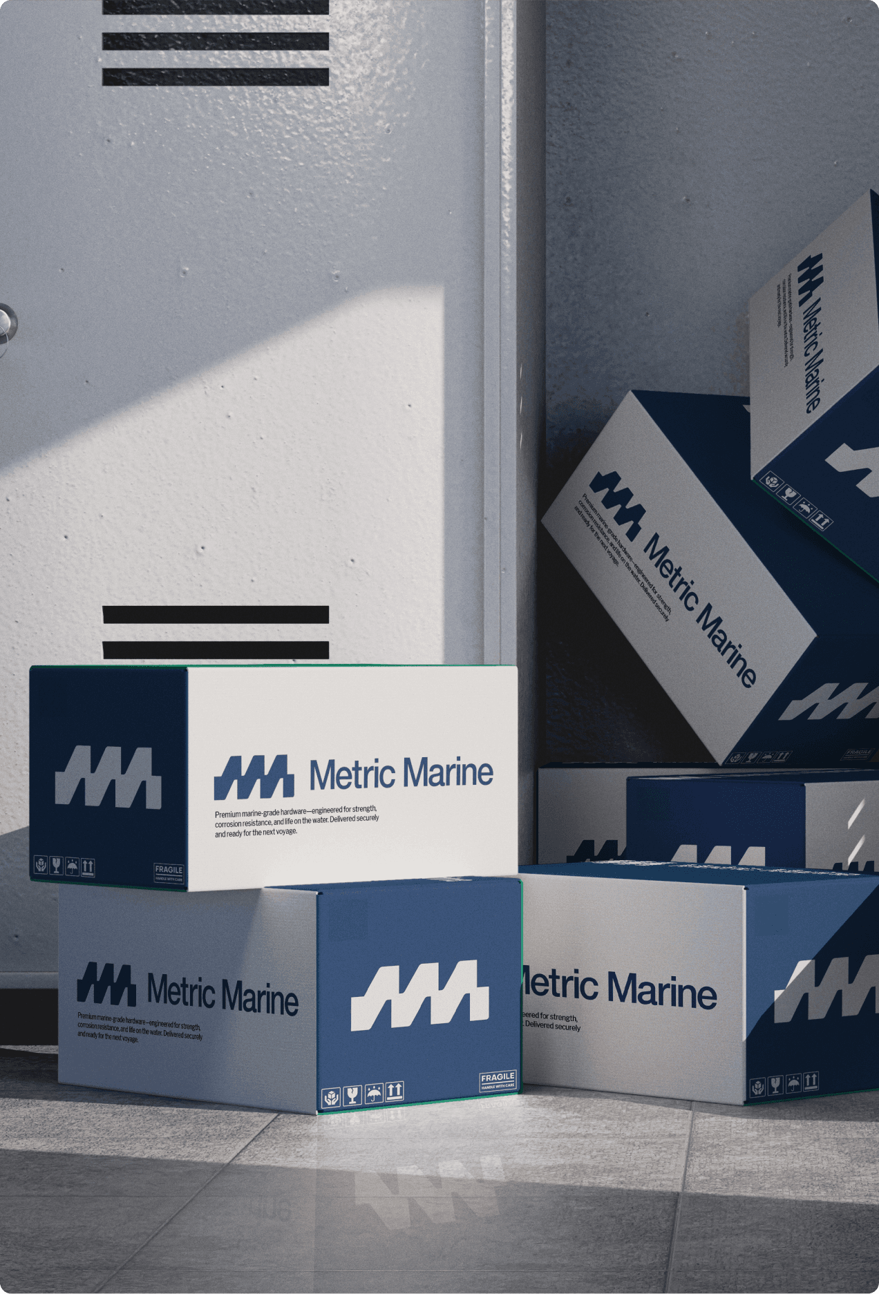 Metric Marine branded shipping boxes stacked near a loading dock door, showing navy and white packaging with the MM logo