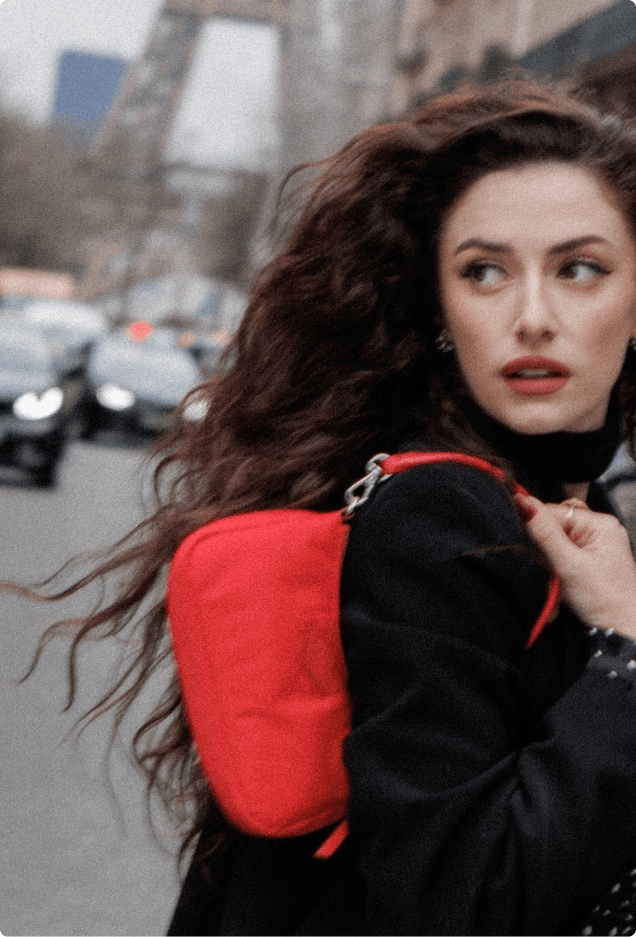 Model in Paris carrying a red MZ Wallace crossbody bag with the Eiffel Tower visible in the background